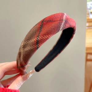 Gros plan sur un serre-tête rembourré en tweed écossais rouge au style vintage