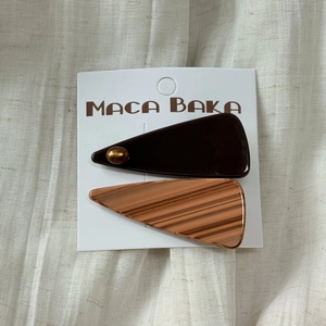 Detail view of acetate triangle hair clip set in coffee brown and wood grain textures