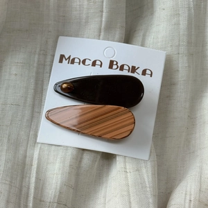 Detail of tortoiseshell patterned acetate hair clips in brown and orange on linen