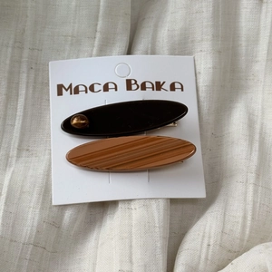 Pair of acetate resin hair clips in dark brown and wood texture on display card