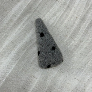 Detail of red polka dot felt fabric hair clip with a cozy winter wool texture