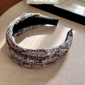 Detailed macro of French style tweed headband featuring purple and green woven texture