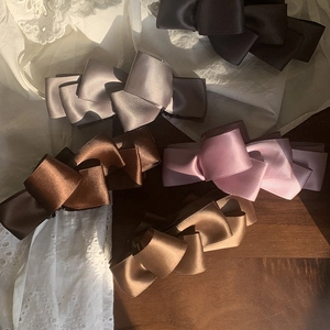 Elegant satin bow banana hair clips in multiple colors on a vintage lace background