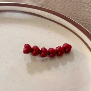 Pinza para el pelo de Año Nuevo con seis corazones rojos brillantes en plato