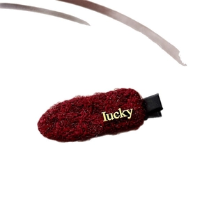 Pinza para el pelo de punto rojo oscuro con letras lucky doradas sobre blanco
