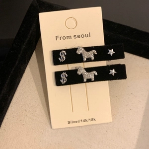 Detail of velvet hair clips with rhinestone horse, dollar sign, and star charms