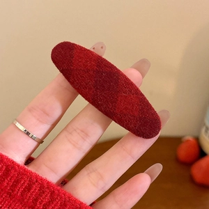 Detail of a red plaid flocking fabric hair clip with a vintage geometric lattice pattern