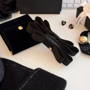Detail einer eleganten schwarzen Bananenspange aus Ripsband mit goldener Knopfverzierung