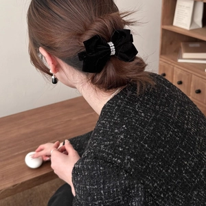 Elegant black velvet bow hair clip with sparkling rhinestones for a vintage female hairstyle