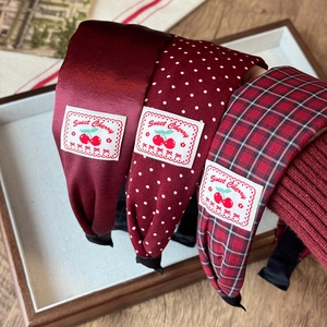 Red plaid and polka dot padded headbands with sweet cherry label on vintage display tray