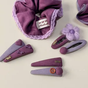 Détail des chouchous en tricot violet et ensemble de barrettes à fleurs faites main