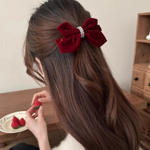 Elegant red velvet bow hair clip with rhinestones shown on model from the back view