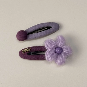 Détail de barrettes en tissu violet avec fleurs en peluche et lettrage doré Hand made