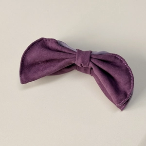 Gros plan détaillé du nœud de barrette en tissu sergé violet foncé aux coutures fines