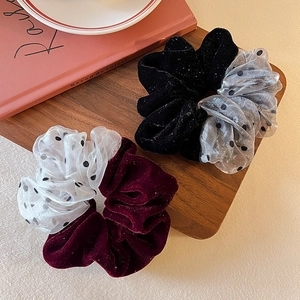 Elegant velvet and polka dot mesh scrunchies displayed on a wooden tray for hair styling