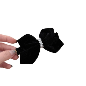 Elegant black velvet bow hair clip with sparkling rhinestones on a clean white background