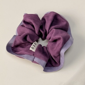 Détail du chouchou en maille violette montrant la texture et l'étiquette logo