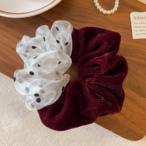 Detail of red velvet and polka dot mesh scrunchie with sparkling glitter texture