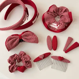 Dettaglio del set di accessori per capelli a quadri rossi con cerchietti e fermagli a cuore