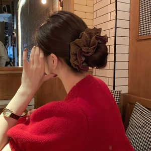 Red and black plaid lace scrunchie worn on ponytail in a cozy indoor setting