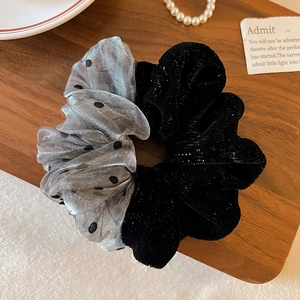 Detail of polka dot mesh and velvet scrunchie on vintage wood with pearl necklace