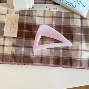 Détail de la pince à cheveux géométrique creuse rose cerise sur fond en tissu doux