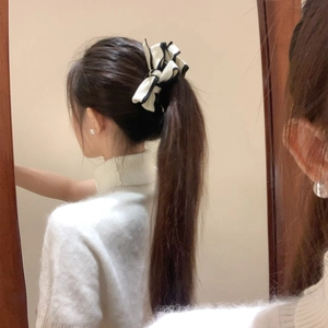 Elegant white fabric bow hair clip with black piping detail shown on model back view