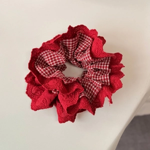 Dettaglio di un elastico per capelli a quadretti rossi con pizzo ricamato vintage