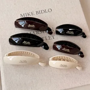 Minimalist 6-piece resin banana hair clips in black, brown and white with gold lettering