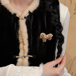 Detailed close-up of a handcrafted Songjin silk pony brooch on a black velvet vest