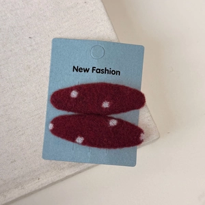 Detail of red plaid BB hair clips with white dots on a blue display card for women