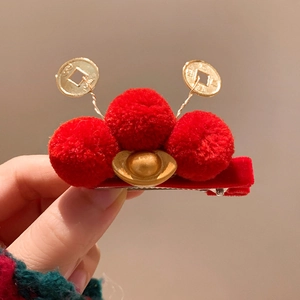 Detail of red plush hair clip with golden sycee and lucky coins for Lunar New Year