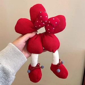 Detail of red waffle fabric hair tie with polka dot bow and plush leg features