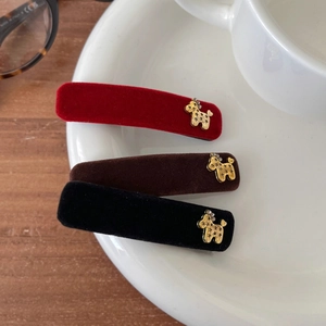 Detail of red, coffee, and black velvet hair clips with golden puppy alloy accents