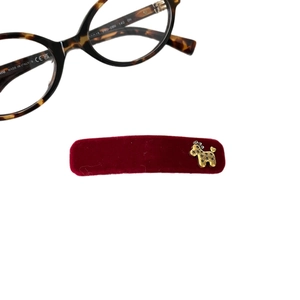 Red velvet hair clip with gold horse charm and star pattern on white background