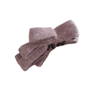Dusty pink knitted bow hair clip for high ponytail with textured fabric on white background