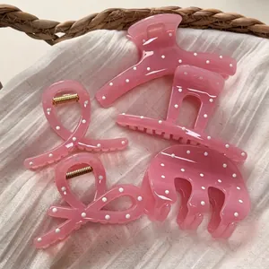Pinces à cheveux rose gelée à pois blancs de quatre styles sur fond de tissu blanc doux
