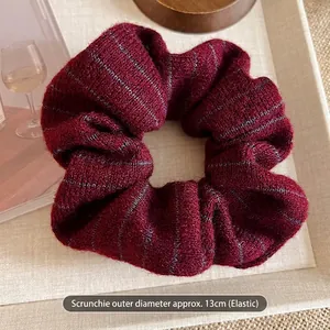 Detail of red striped knit scrunchie showing 13cm outer diameter and elastic stretch