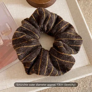 Close-up of 13cm brown striped knit hair scrunchie with elastic texture detail