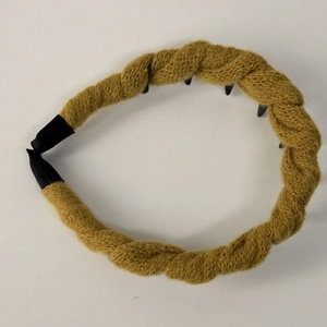 Dettaglio del cerchietto a maglia intrecciata giallo zenzero con denti antiscivolo