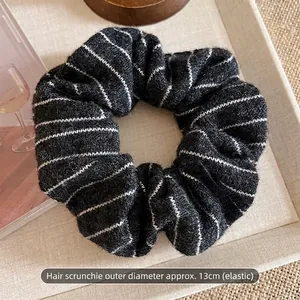 Close-up of vintage knitted striped scrunchie with 13cm diameter and elastic texture