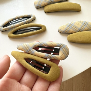 Yellow plaid and solid mustard fabric snap hair clips held by hand for women