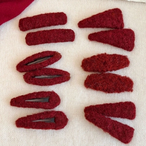 Set of 10 dark red plush heart hair clips in various shapes on a knit background
