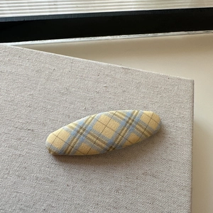 Detail showing the woven texture and yellow plaid fabric of this handmade hair clip