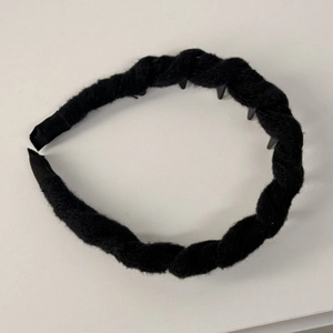 Dettaglio dei denti antiscivolo e della trama in lana nera lavorata a maglia della fascia