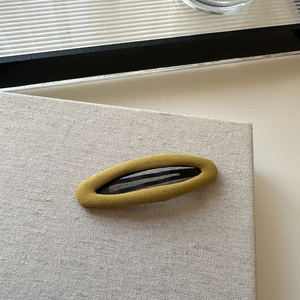 Detail shot of mustard yellow fabric texture on a handmade Korean style hair clip accessory