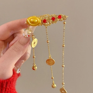 Detail of Chinese New Year hair clip with golden sycee ingots and tassel pendants