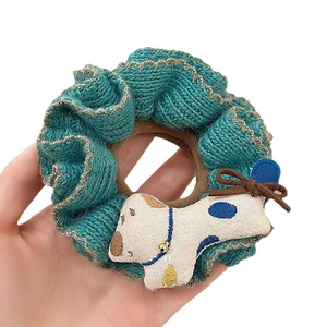 Green knit scrunchie with handmade cream puppy doll and gold trim for winter style