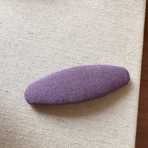 Detailed macro view of purple fabric texture on the elegant oval clip over linen