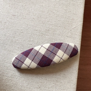 Close-up of a Korean style purple argyle checkered fabric oval hair clip on burlap
